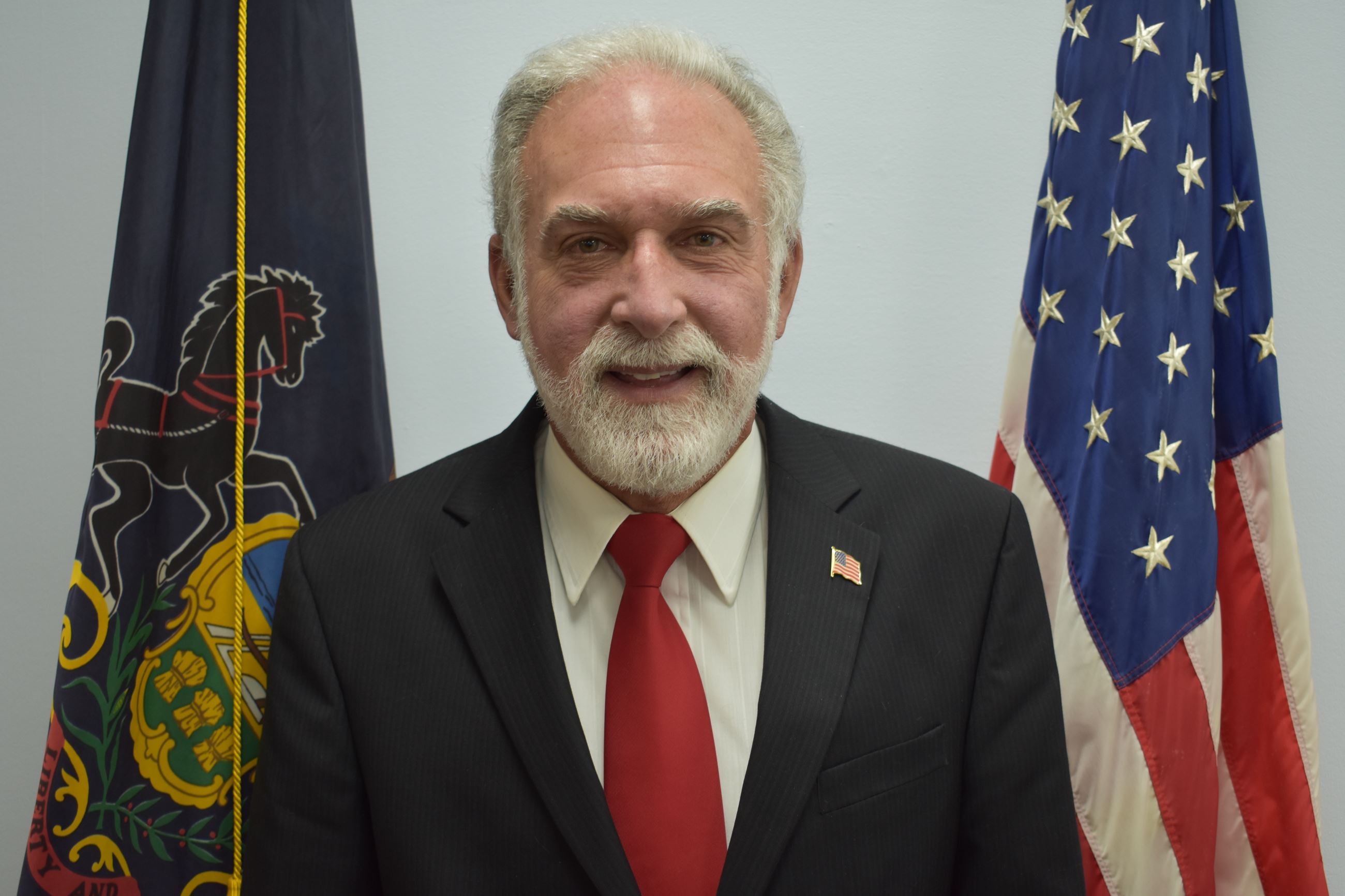 Commissioner Rich Gray with Flags in the Background
